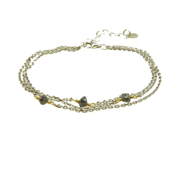 Dreireihiges Armband mit silbernen Ketten, goldenen Akzenten und dunklen Rohdiamanten.