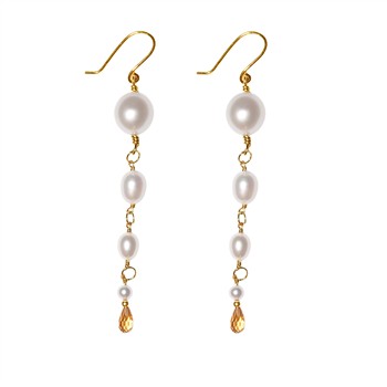 Elegante Ohrringe mit weißen Perlen, goldenen Verbindungen und bernsteinfarbenen Steinen.